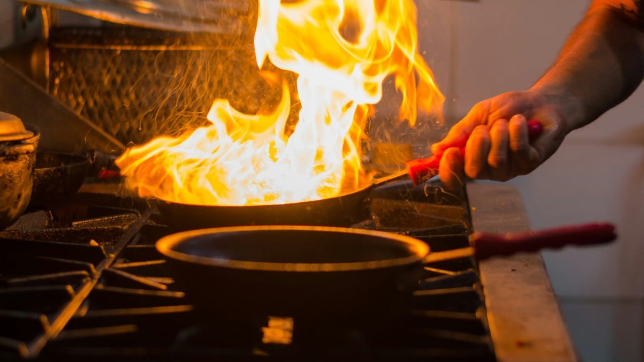 chef cooking with active frying pan